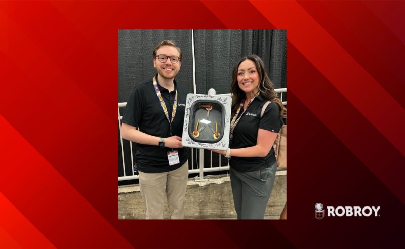 Stephanie Ellis, Director of Marketing and Joshua Bumpas, Marketing Project Manager holding recreated Flux Capacitor